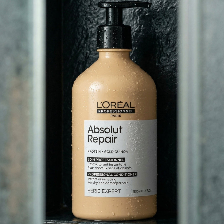 L'Oreal Absolut Repair Conditioner bottle on a dark tiled wall