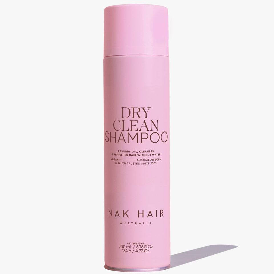 Pink bottle of NAK Hair Dry Clean Shampoo on a white background